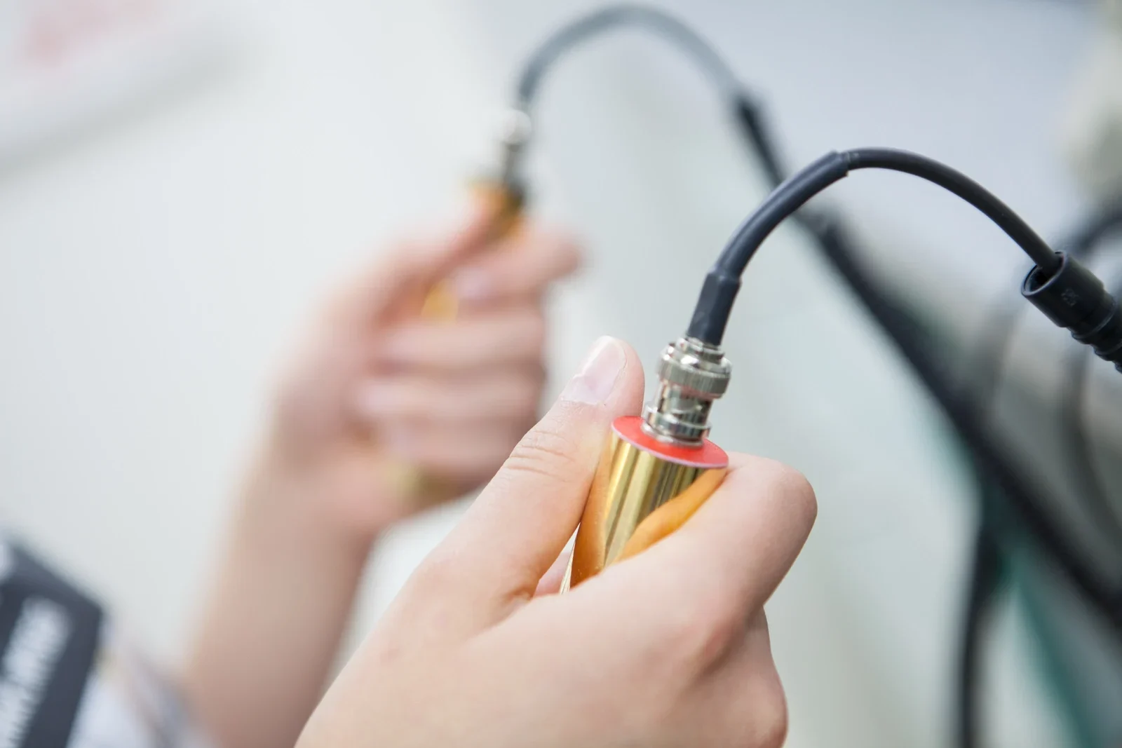 Pacjent trzymający dwie elektrody w trakcie biorezonansu.